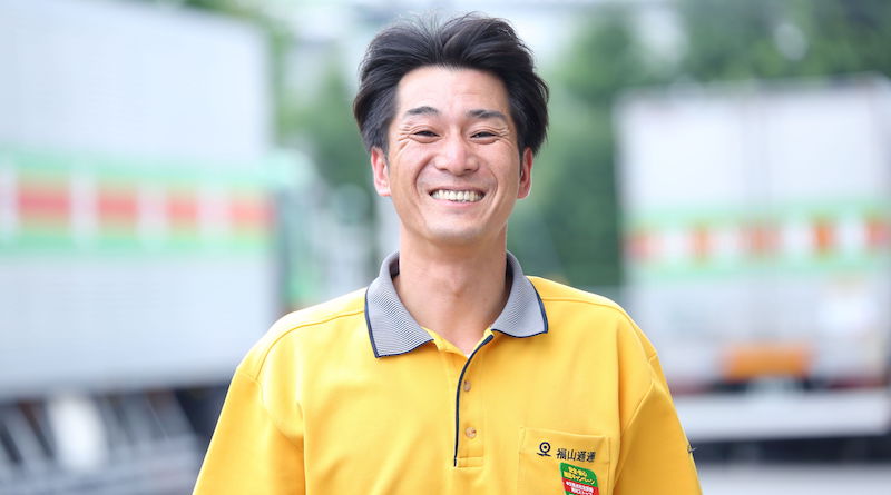 A Fukuyama Transporting employee wearing a yellow uniform.